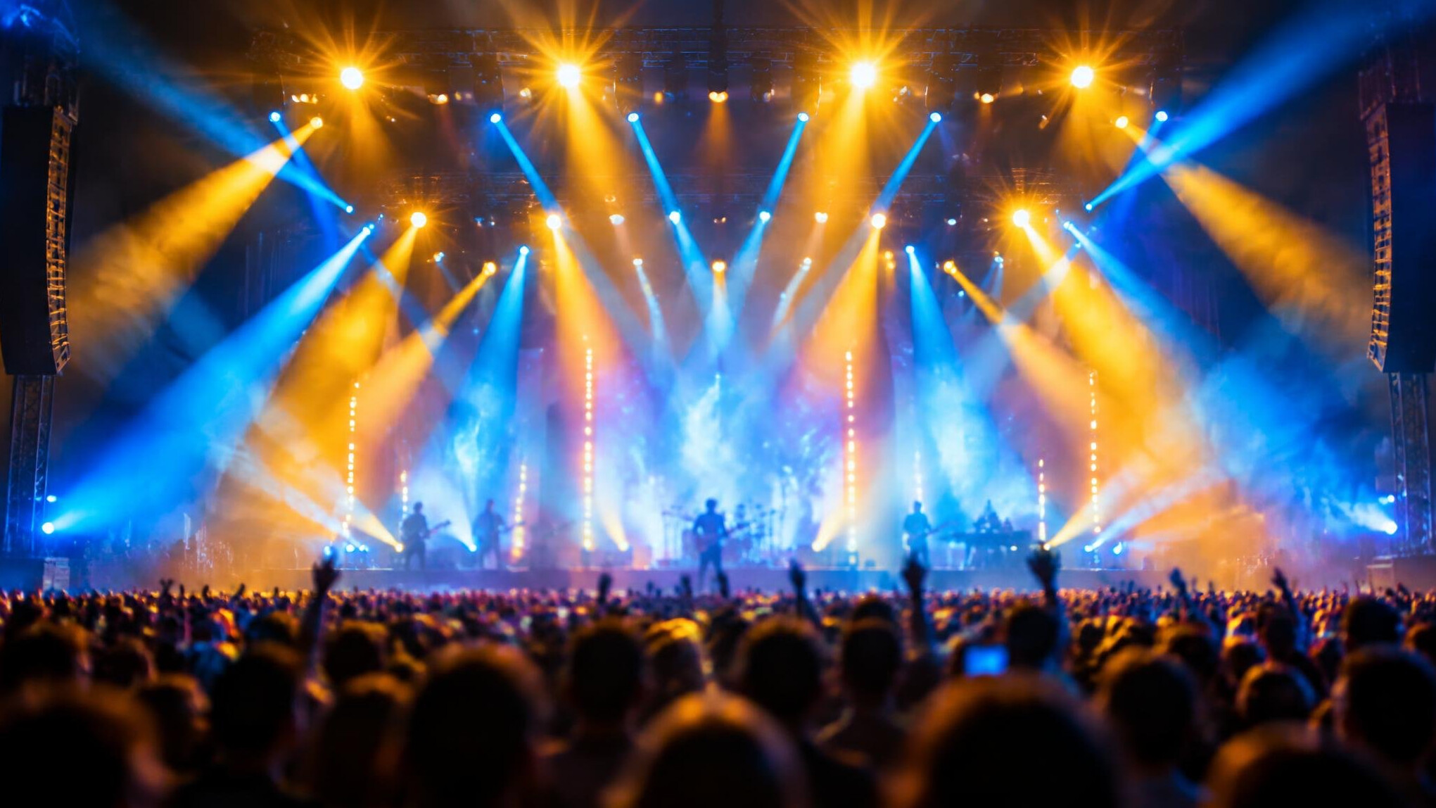 Colorful stage lights above a concert crowd