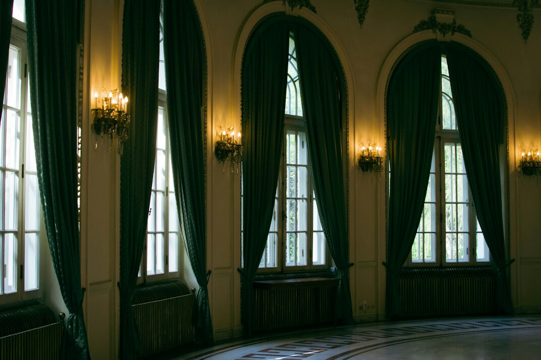 Empty theatre stage with a spotlight and velvet curtains